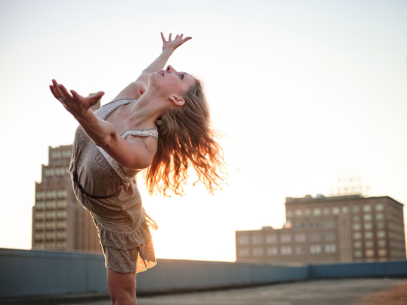 A female soloist dances on a rooftop.