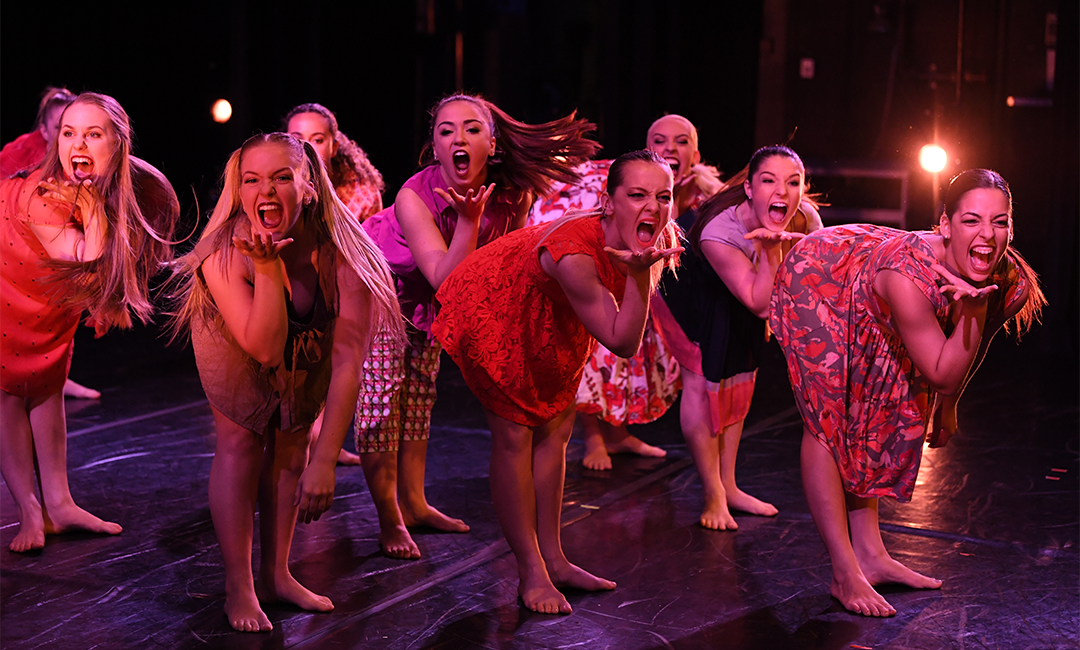 Group of women student dancers on stage engaged in an expressive performance