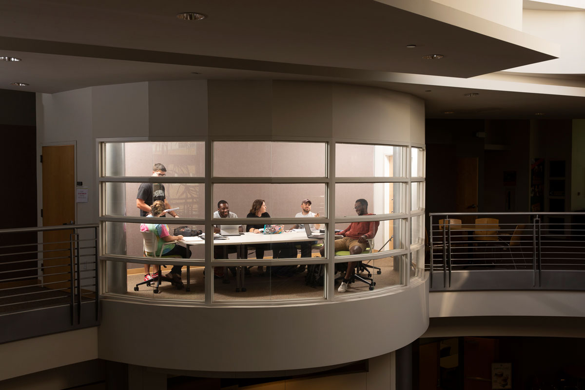 Students collaborate in a conference room overlooking the Davis College of Business & Technology lobby.