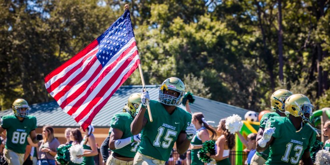 JU football player running with the American flag. 