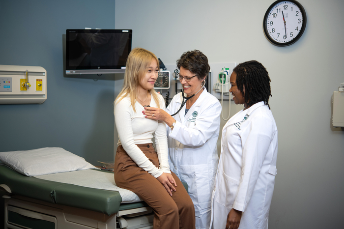 Two nursing professionals checking vitals of a patient