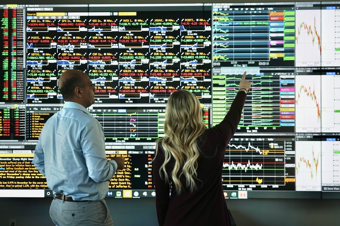 people pointing at a wall of green and red data points
