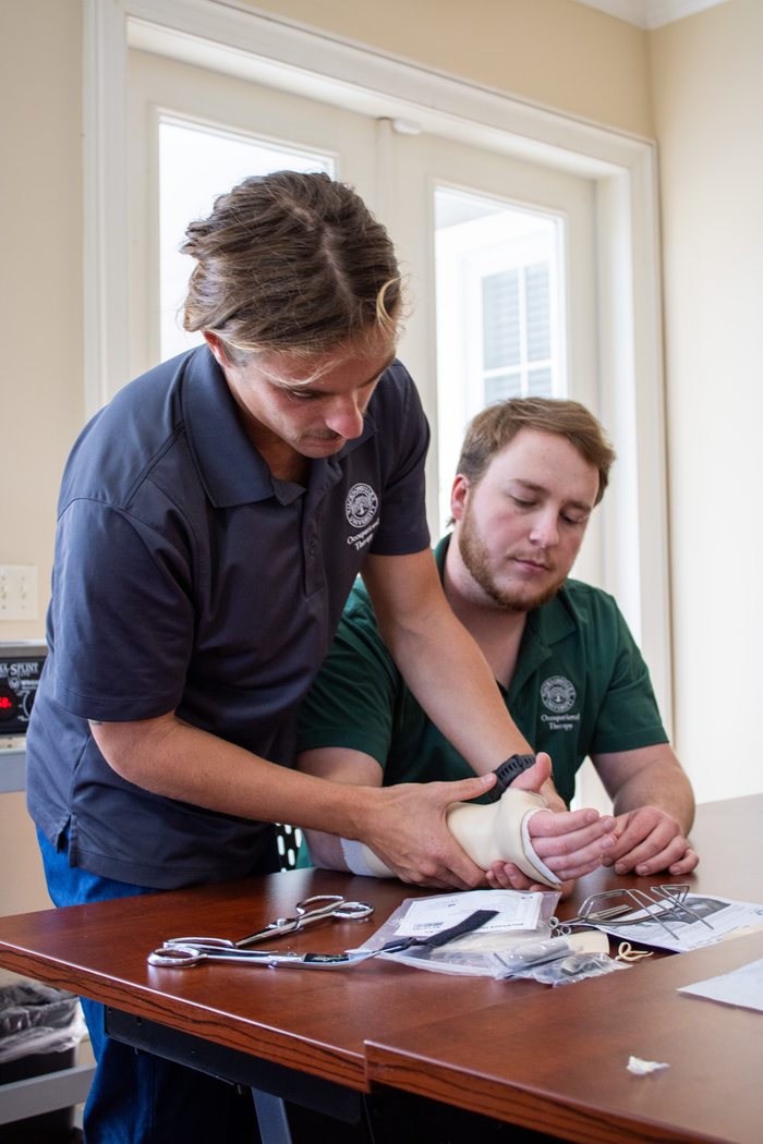 Two Occupational Therapy students demonstrating tools used during sessions