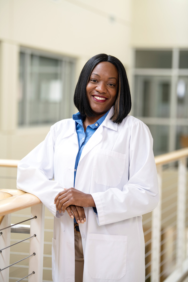 A smiling respiratory therapist in a lab coat.