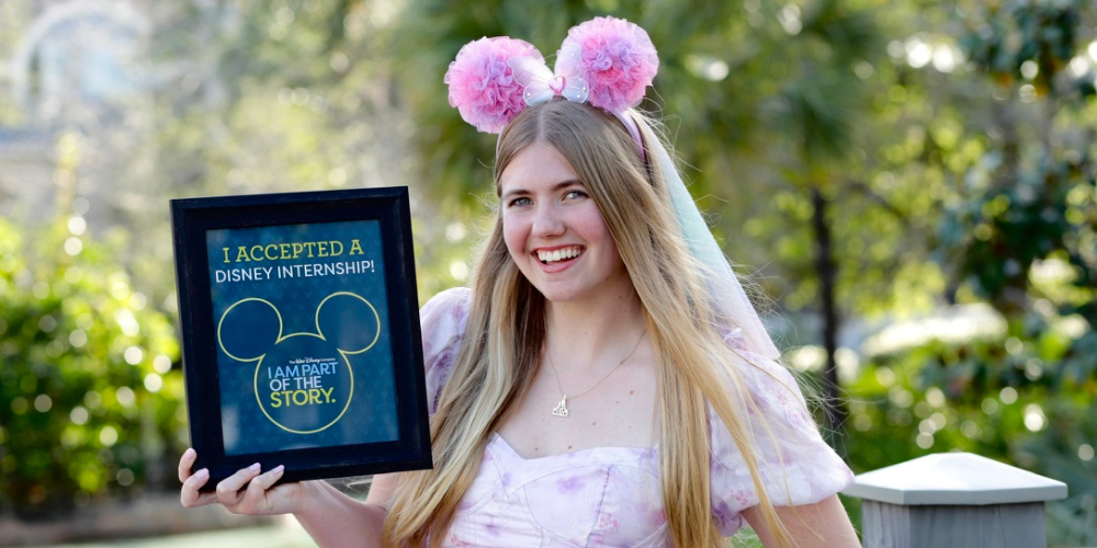 Skye student holding a framed poster signifying her acceptance into Disney internship program.
