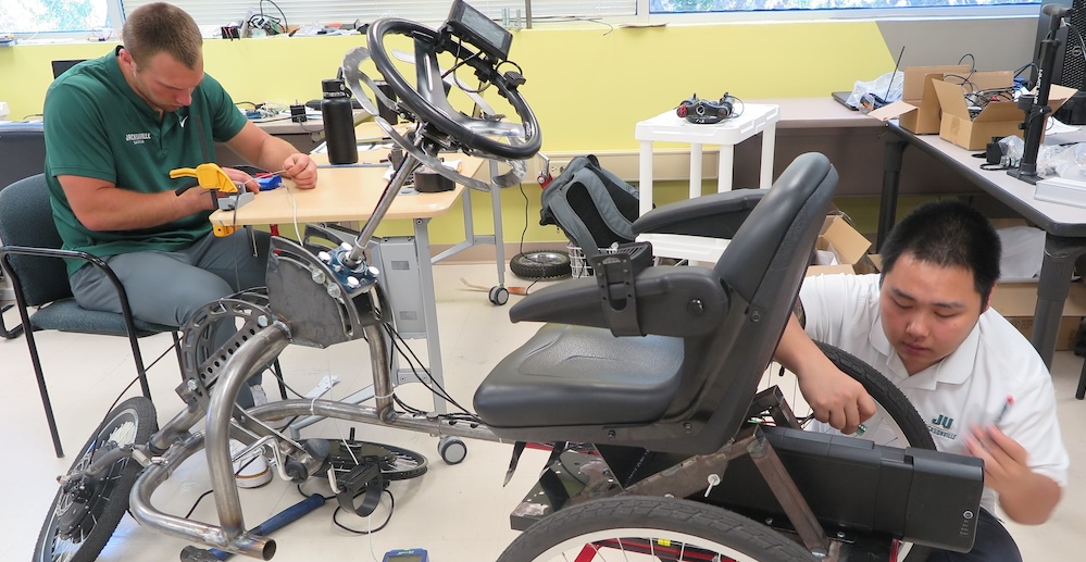 Engineering students working on adaptive trikes