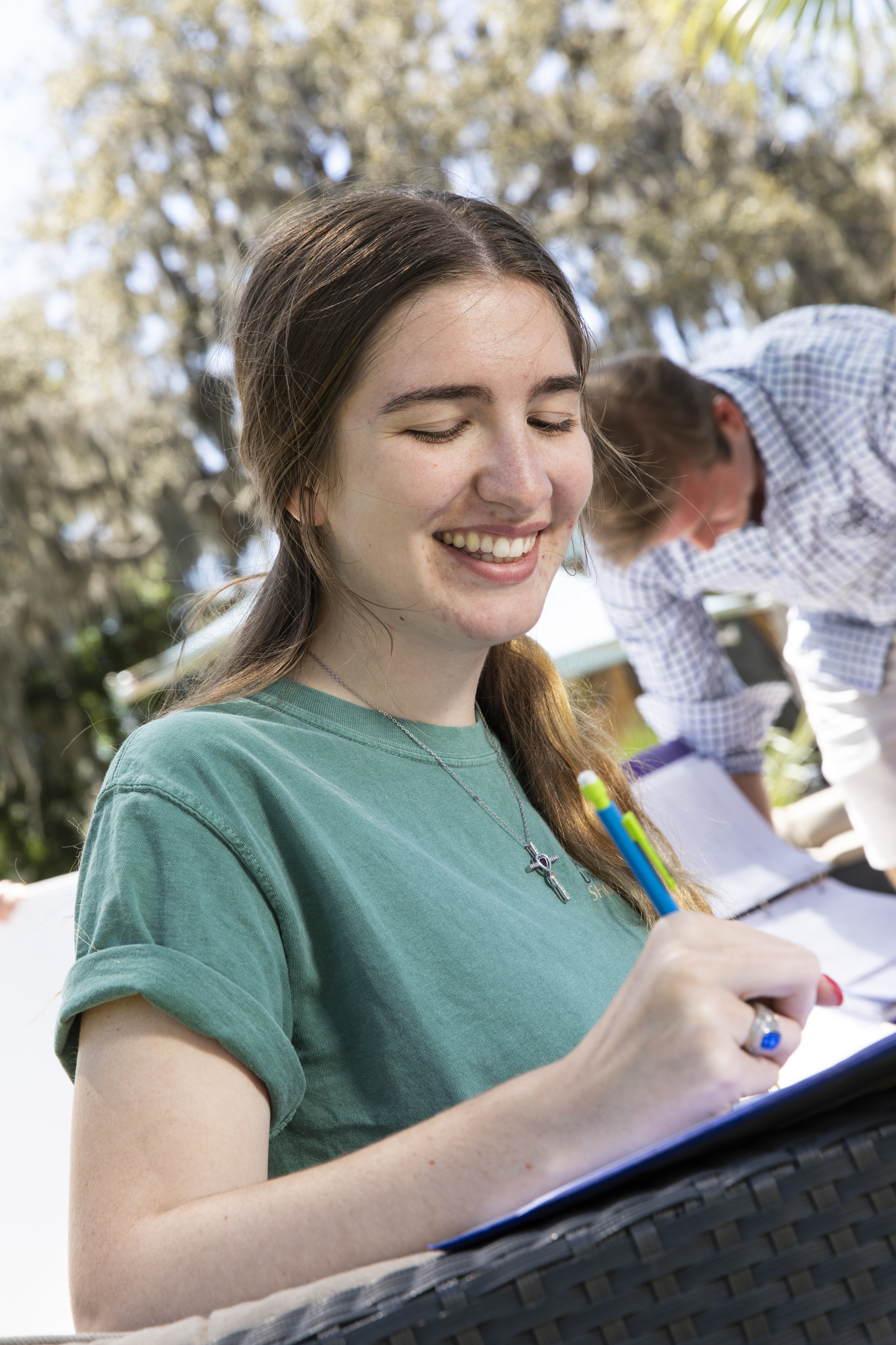 Female student writing in a notebook.