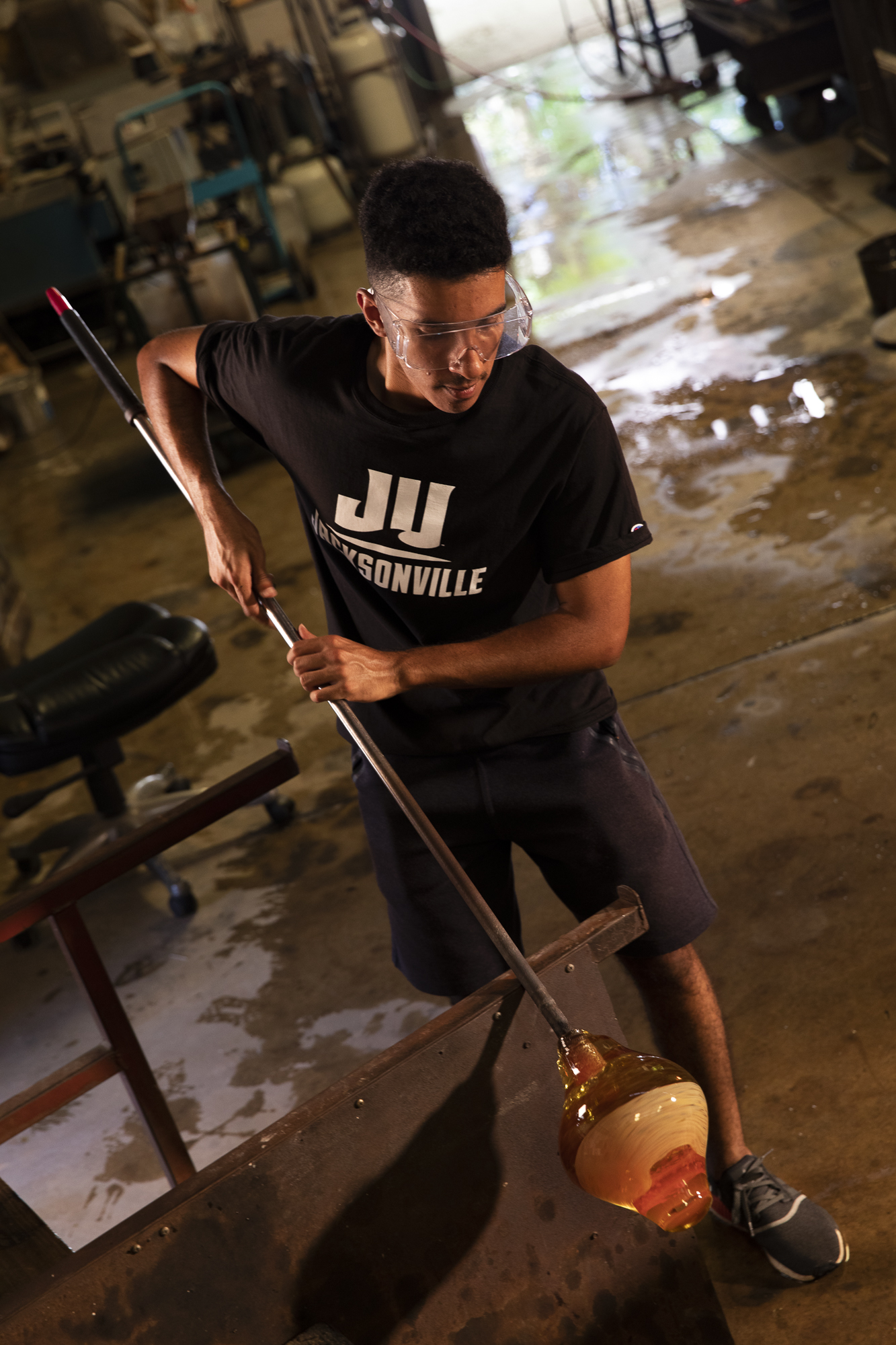 Male glassblowing student working on a piece. 