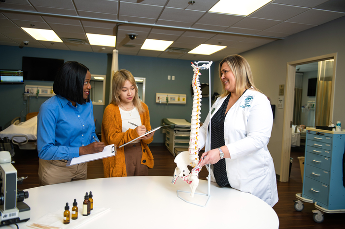 A nurse educator using a model to teach students.