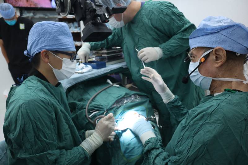 Two dental implantology residents performing dental implant surgery with Dr. Hilt Tatum