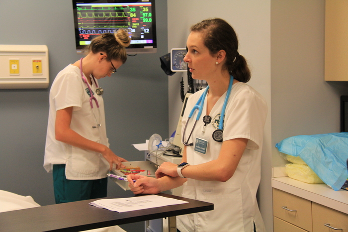 Two nursing students reading vitals