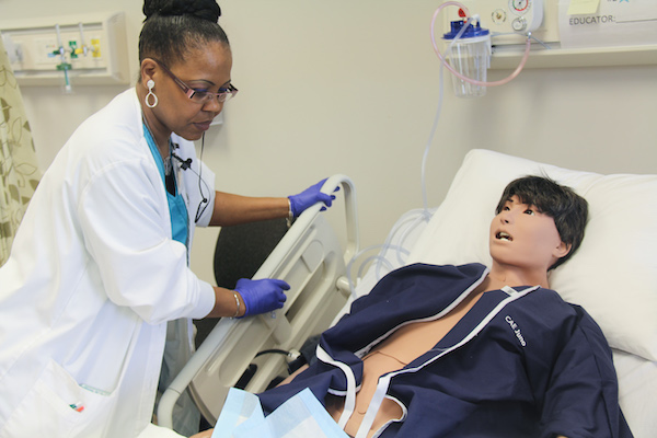 A nurse practitioner student working on a model patient in the simulation center.