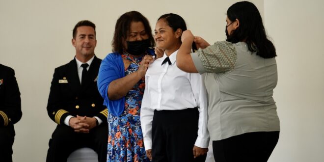 Ensign Jennifer Loyd receives a piece of her uniform from family members.