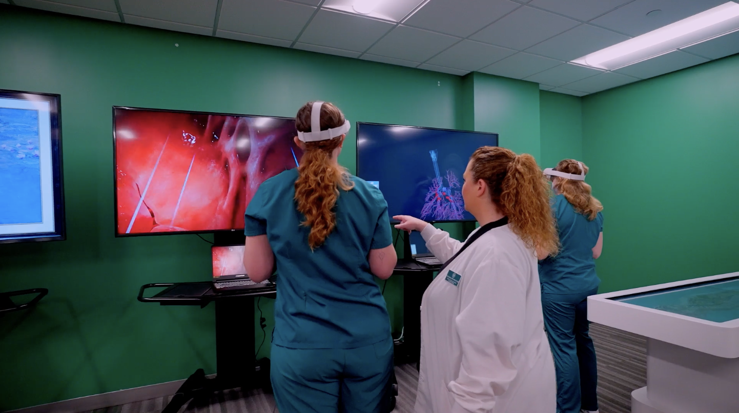 Two female nursing students using a VR system to simulate a procedure on a coronary artery