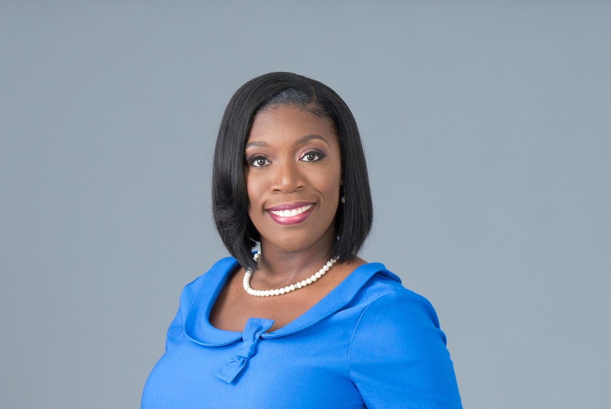 Tameka Gaines Holly smiling for a professional headshot.