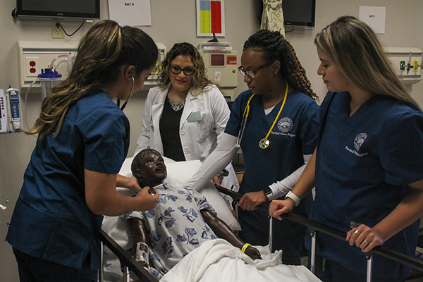 Four nurses practicing procedures on healthcare simulation mannequin