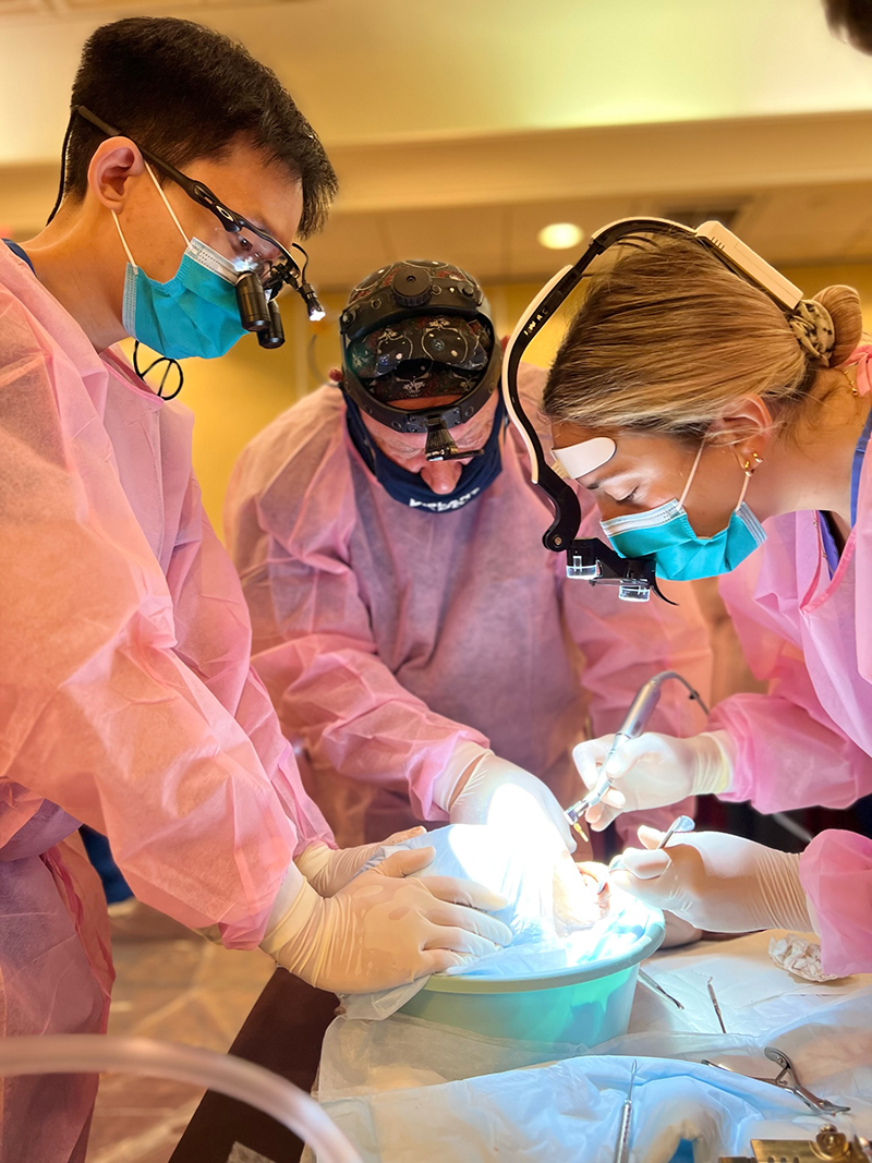 Implantology residents performing surgery on a patient