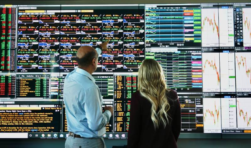 Professor teaching students at the technology wall. 