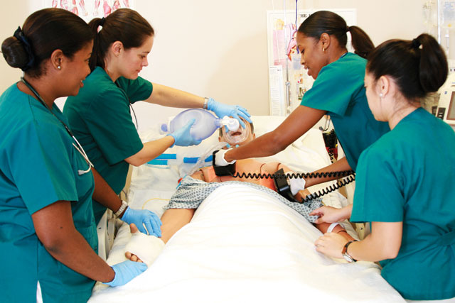 Four nurses practicing procedures on healthcare simulation mannequin