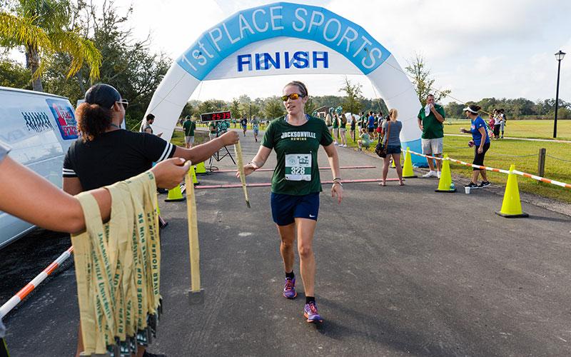 A runner getting her medal after completing the River House Run