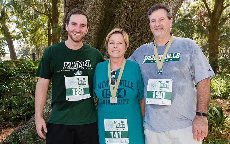 Three runners posing at the River House after the run