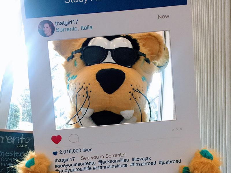 The Jacksonville Jaguars mascot poses with an Instagram cutout promoting study abroad.