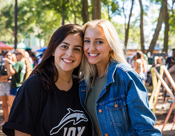 Two students in JU athletics gear smile for a picture.