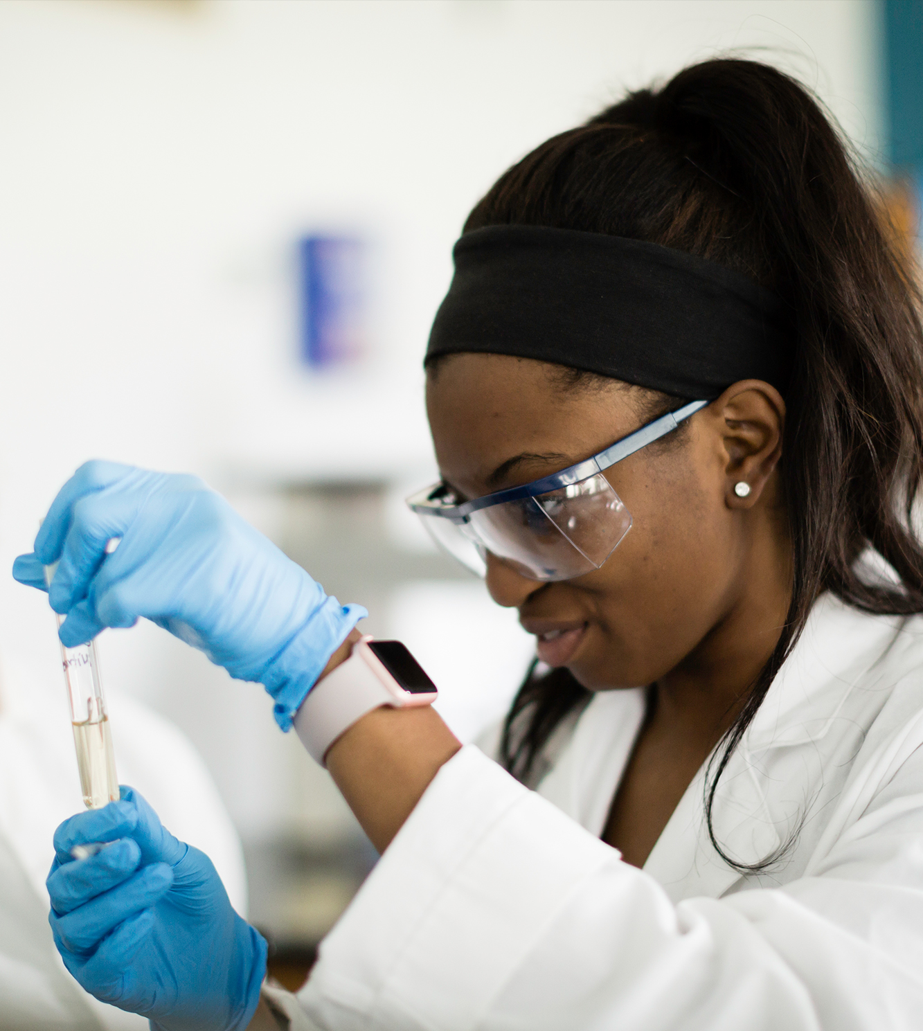 Photo of student in chemistry class with a test tube. 