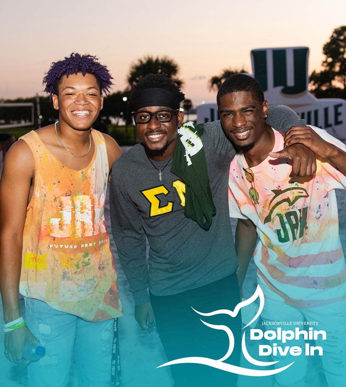 Three students smiling at an on-campus event. 