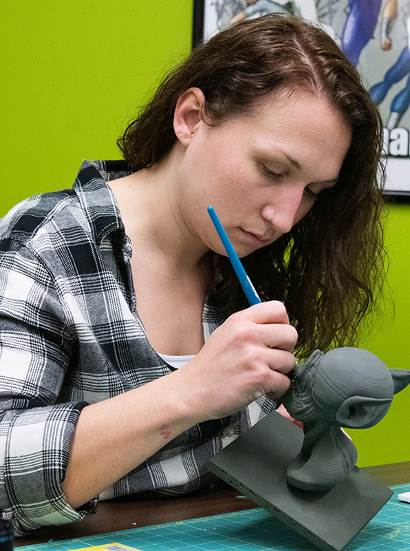 A student examines a dolphin 3D print.