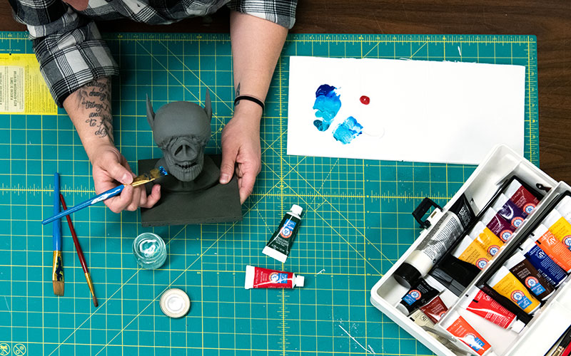 A student sculpts a model to be used in animation.