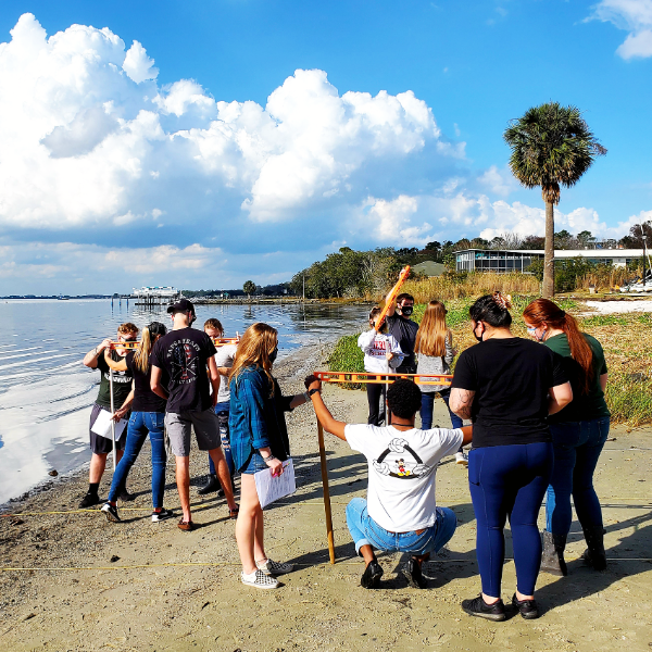 Marine biology students taking measurements on the beach.