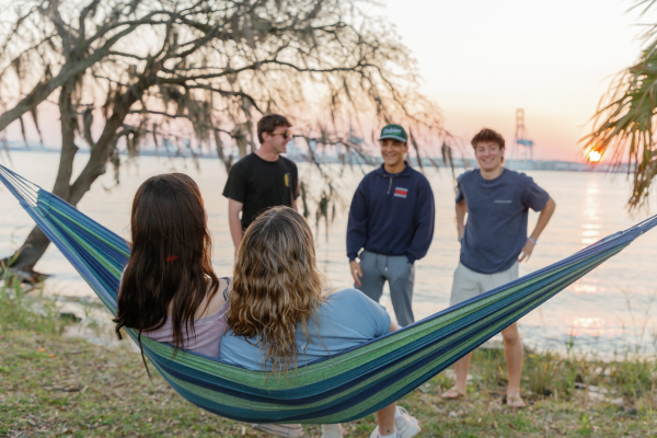 A group of students lounging in hammocks by the St. Johns River.