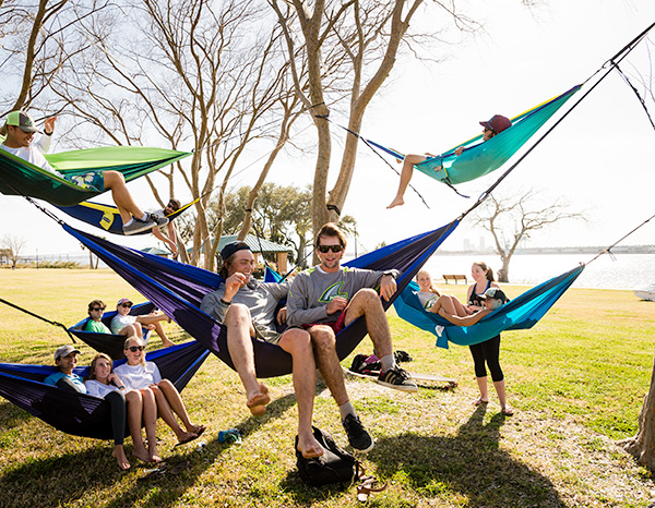 A group of students lounging in hammocks by the St. Johns River.