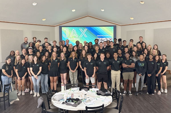Students wearing a Campus Recreation and Wellness hoodie in the gym's office.