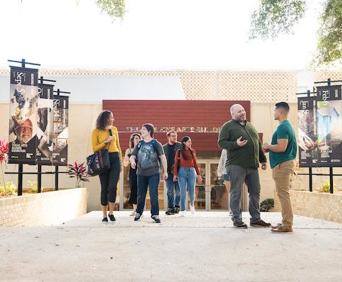 a group of people walking in front of the entry to the Alexander Brest Gallery