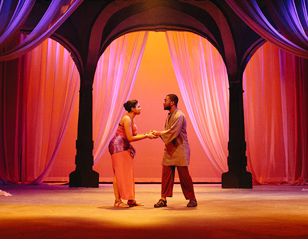 Two students perform on stage in Aida.