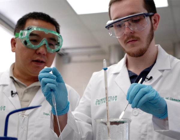 Chemistry & Physics student with professor working at a lab