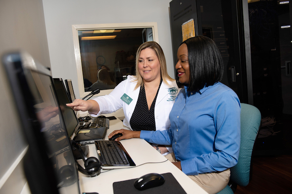 Two nursing professionals working at a computer.