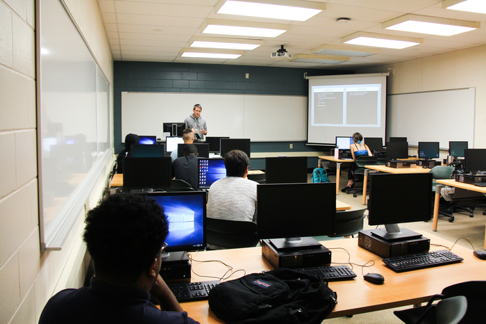 Student listening to the professor in a computer class.