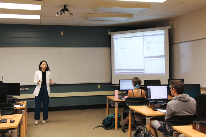 Professor teaching student in a computer class.