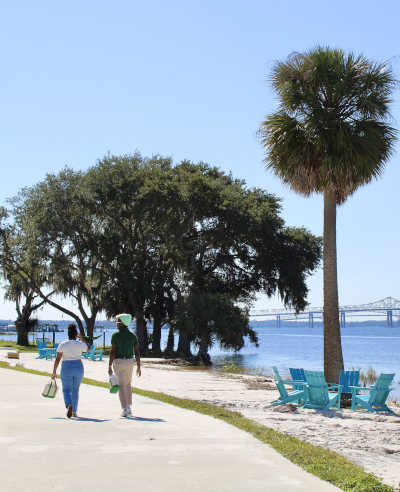 Two students walking along Jacksonville University Naagard Docks.