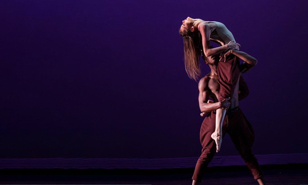 A male holding up a female partner during a dance performance