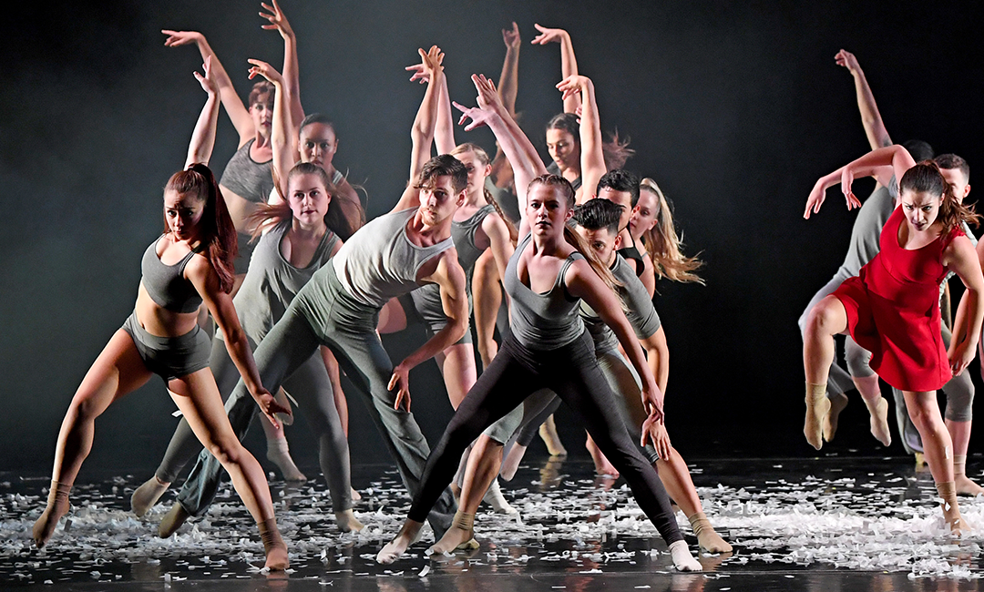 A large group of Jacksonville university dancers on stage with high energy