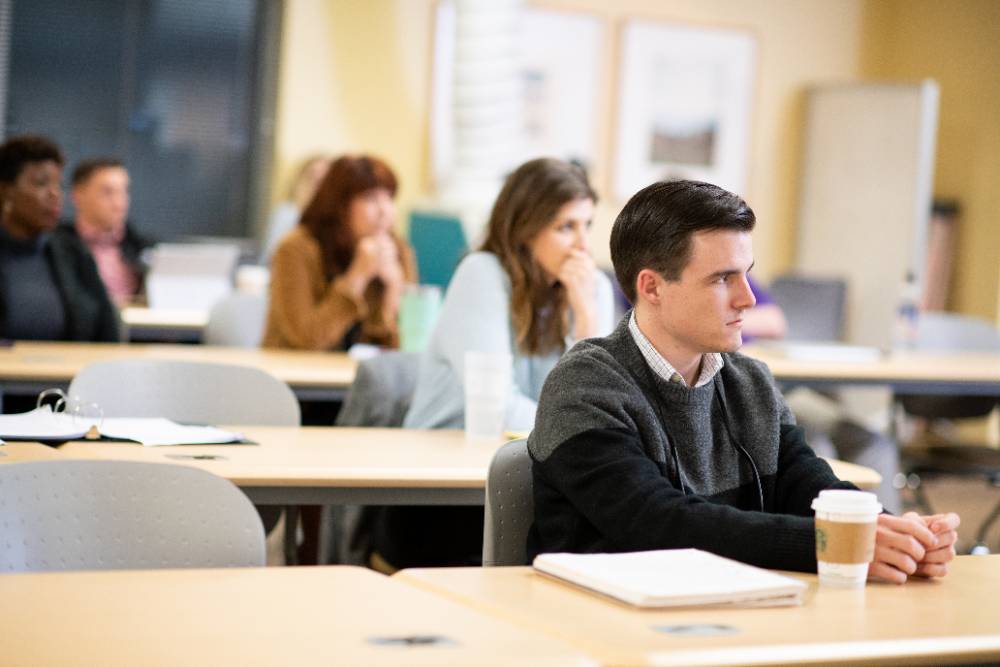 Student sitting in class intently listening to the professor.