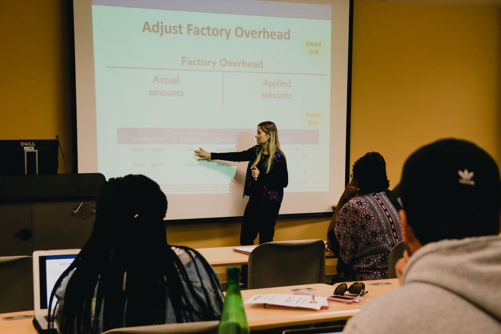 Woman economics teaching in front of a class 