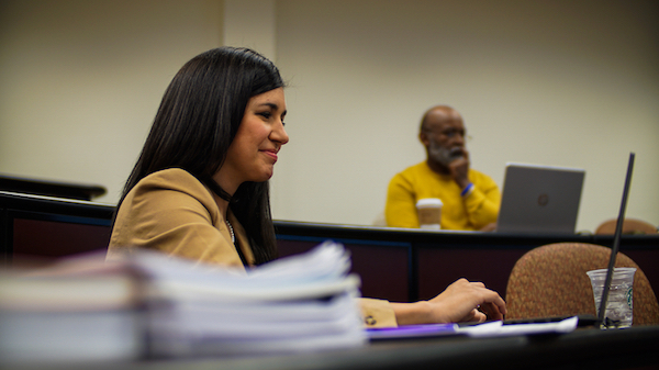 A female student looking at her laptop computer during a lecture.