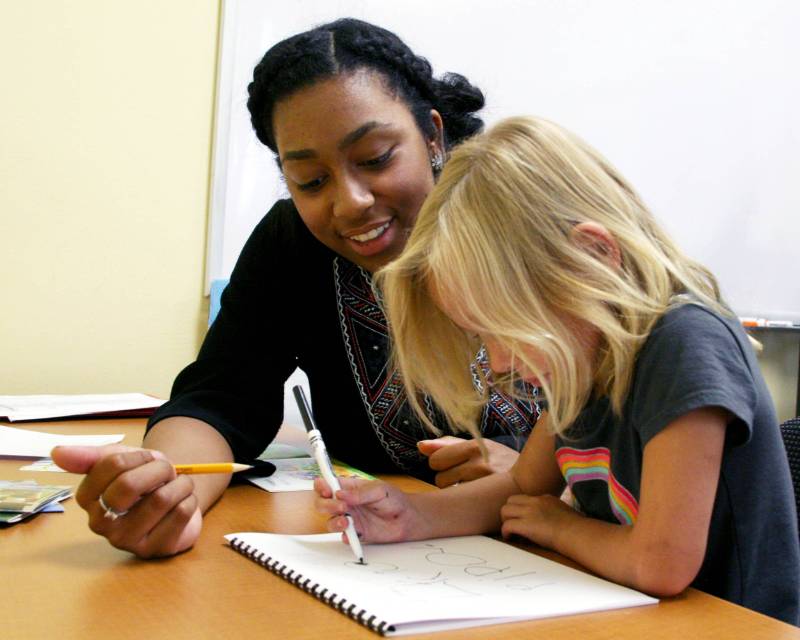 Student teacher helps young child with studies.