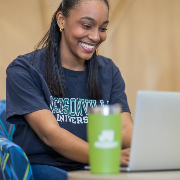 A female student looking at a laptop screen. 