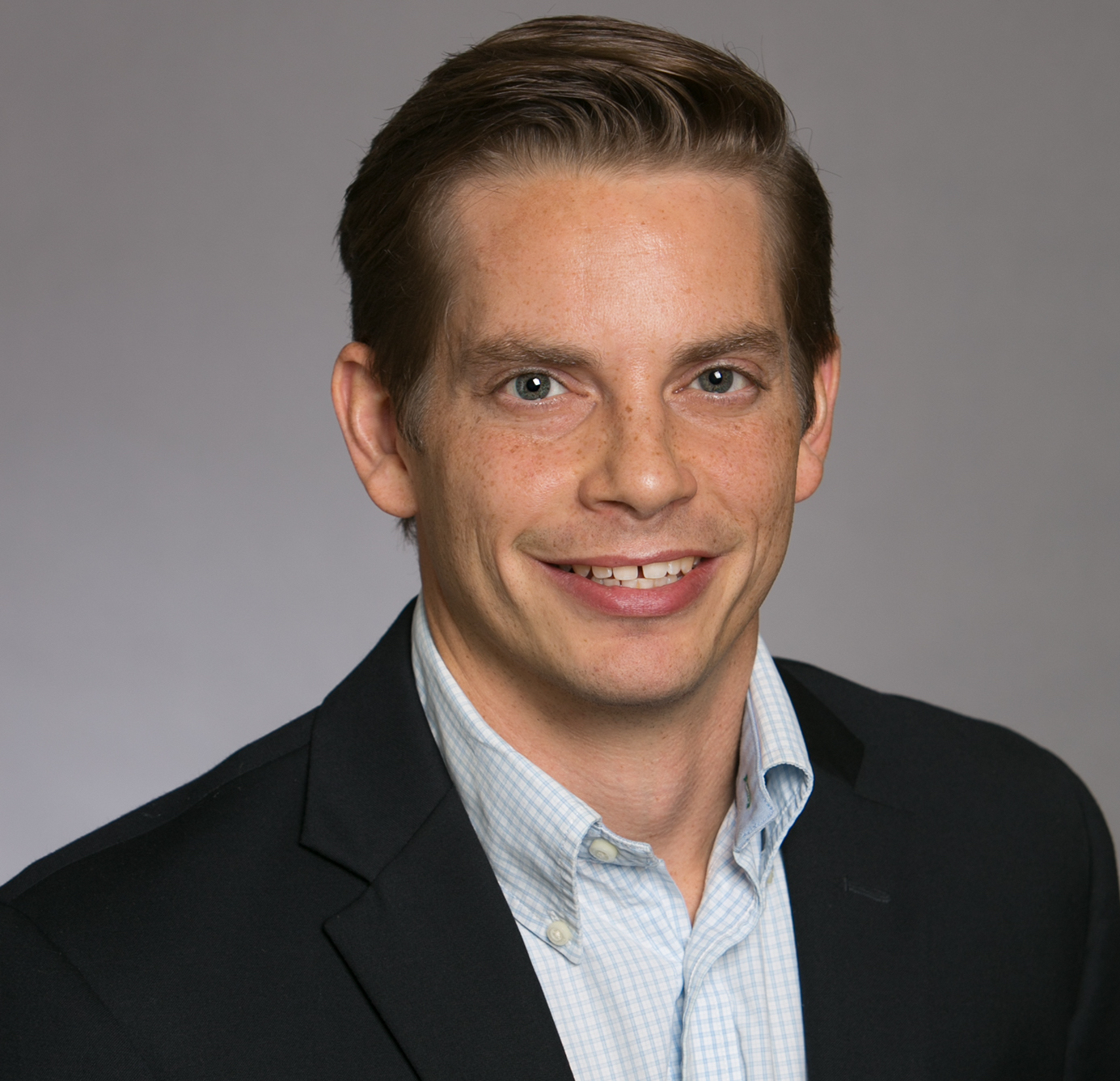 Male EMBA student, Timothy Sherman, smiling for a professional headshot photo.